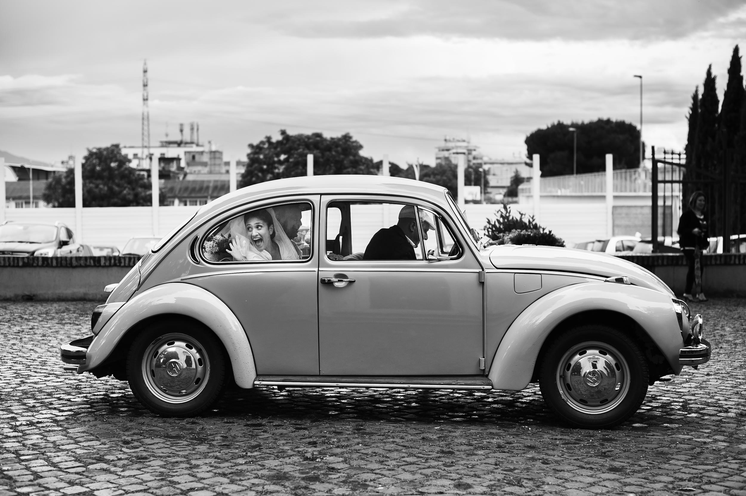 the bride arrives in old volkswagen beetle italy black and white wedding photography