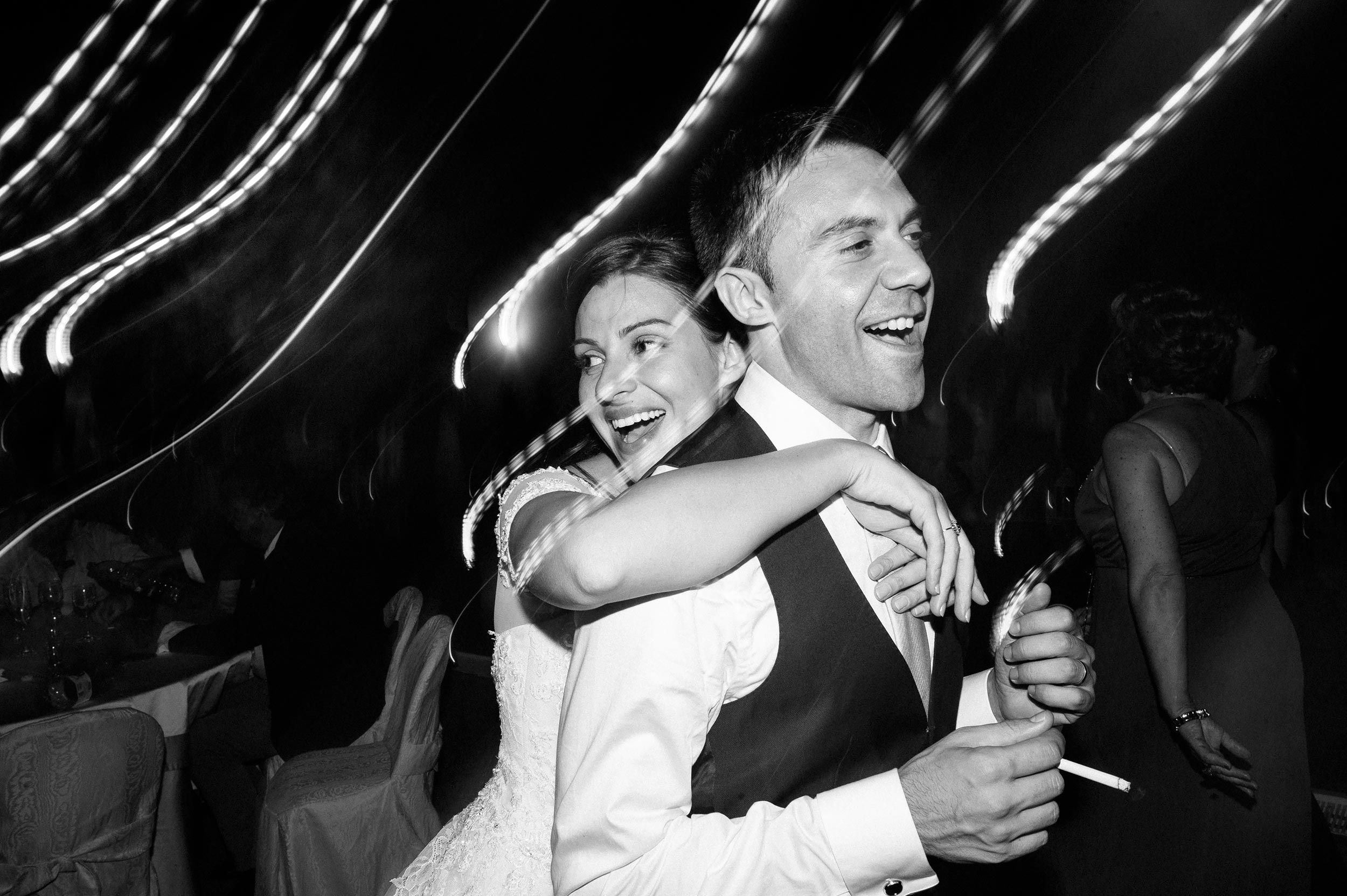bride hugs the groom during wedding reception black and white wedding photography