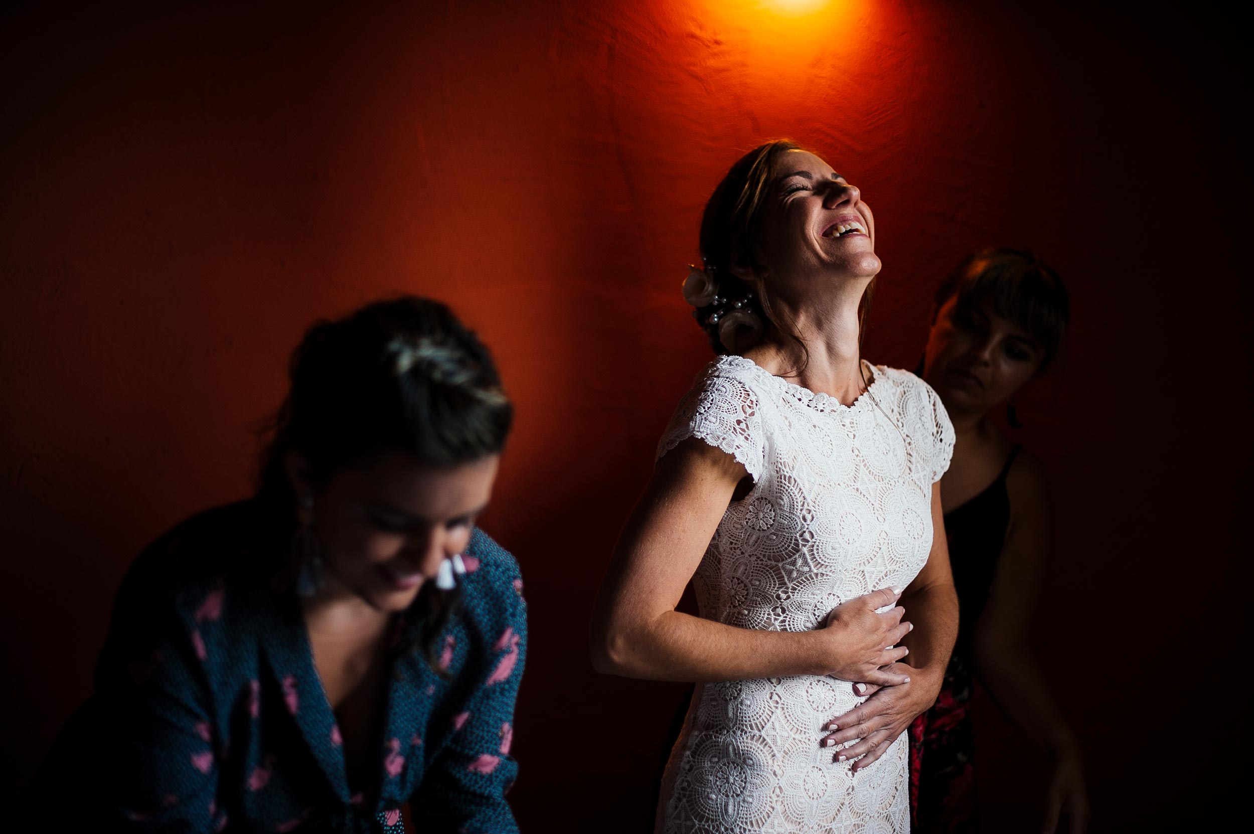 bride getting ready against red wall italian wedding reportage by Alessandro Avenali