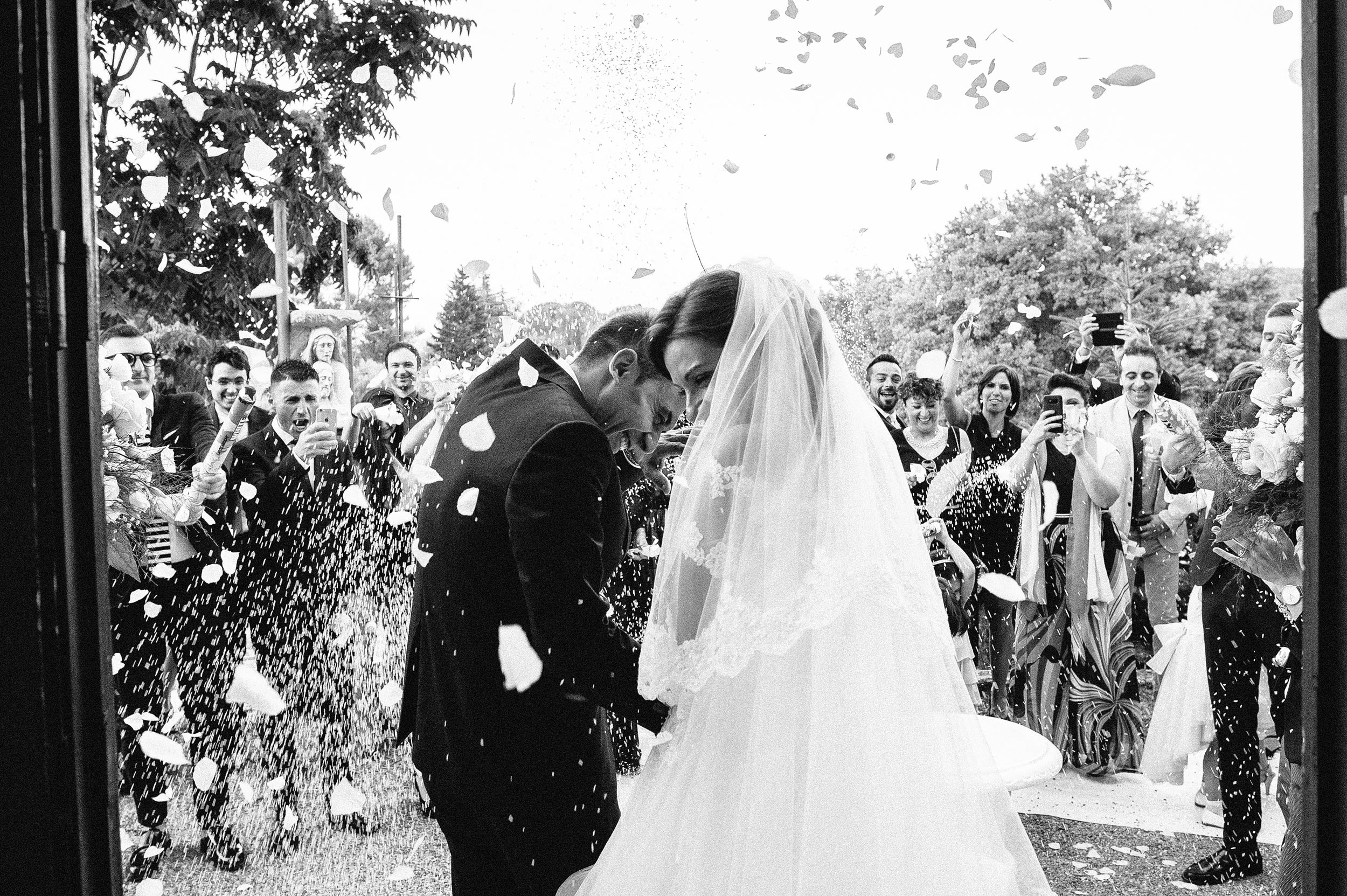 wedding in southern italy confetti rice outside the church black and white wedding photography
