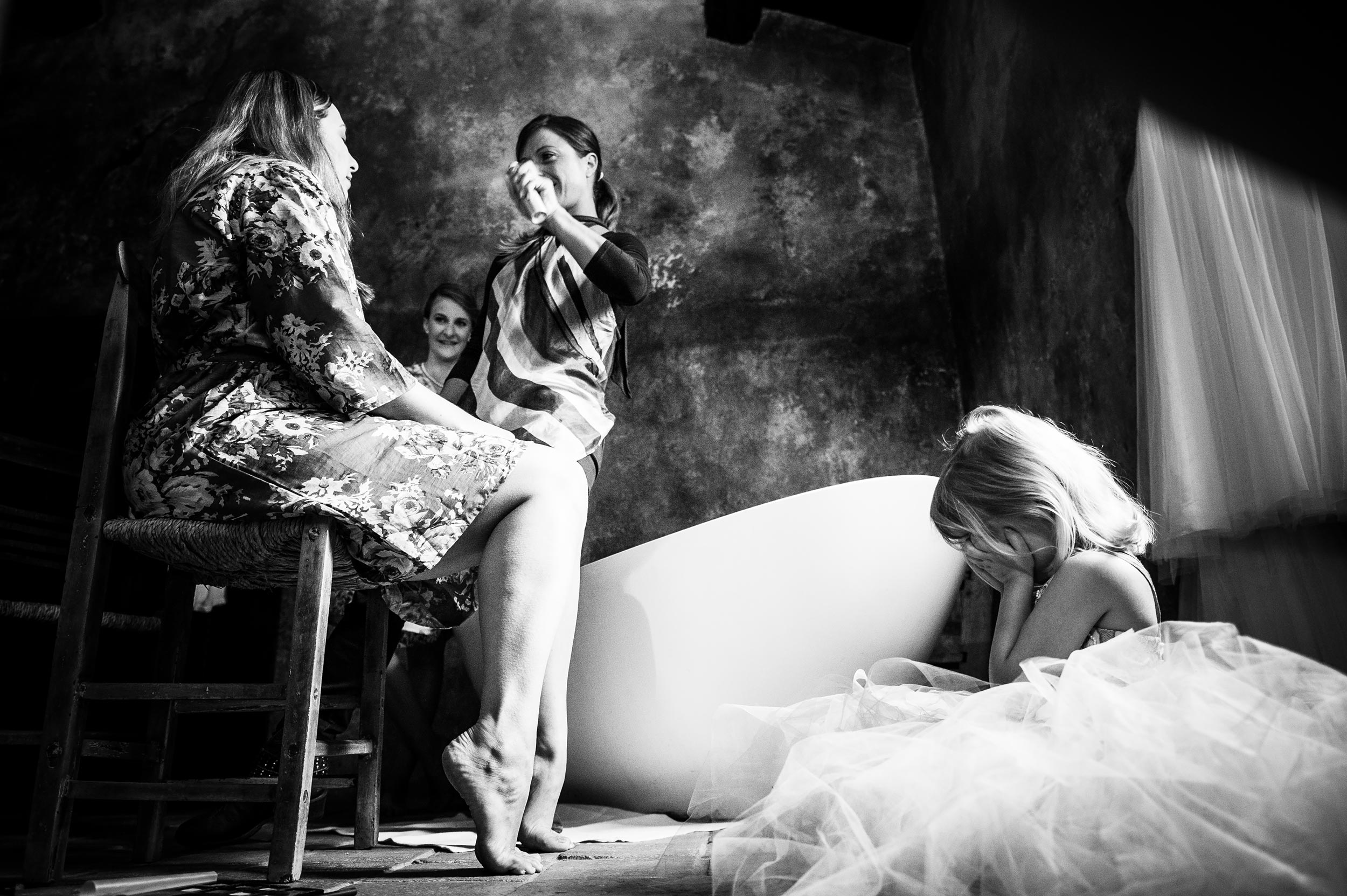 girl puts her hands on her face while mom get sprayed during getting ready black and white wedding photography