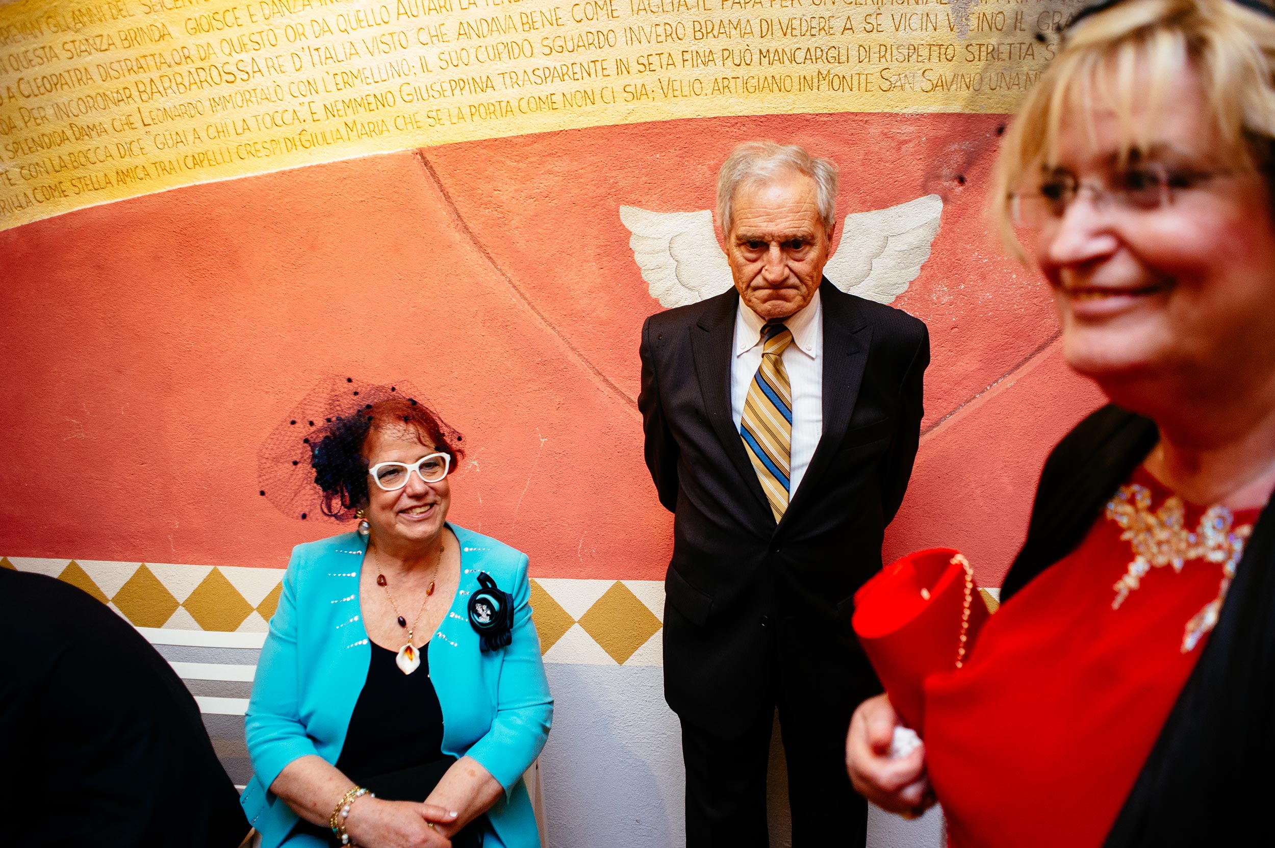grumpy man with angel wings street photography wedding in italy