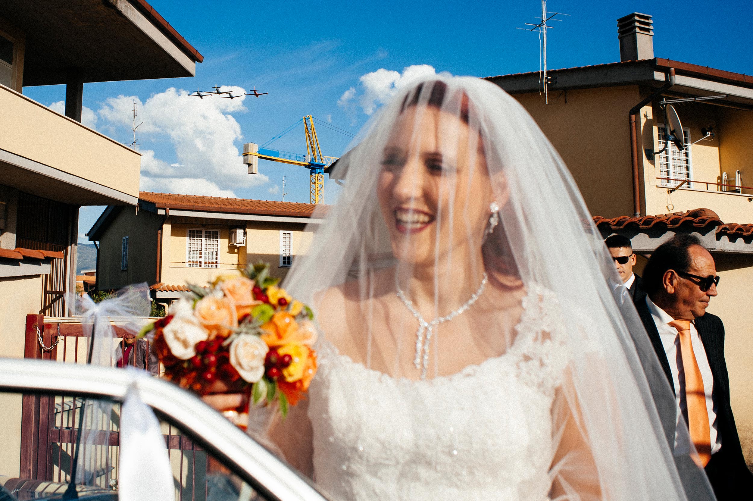 bride going to ceremony while aircrafts pass over her head