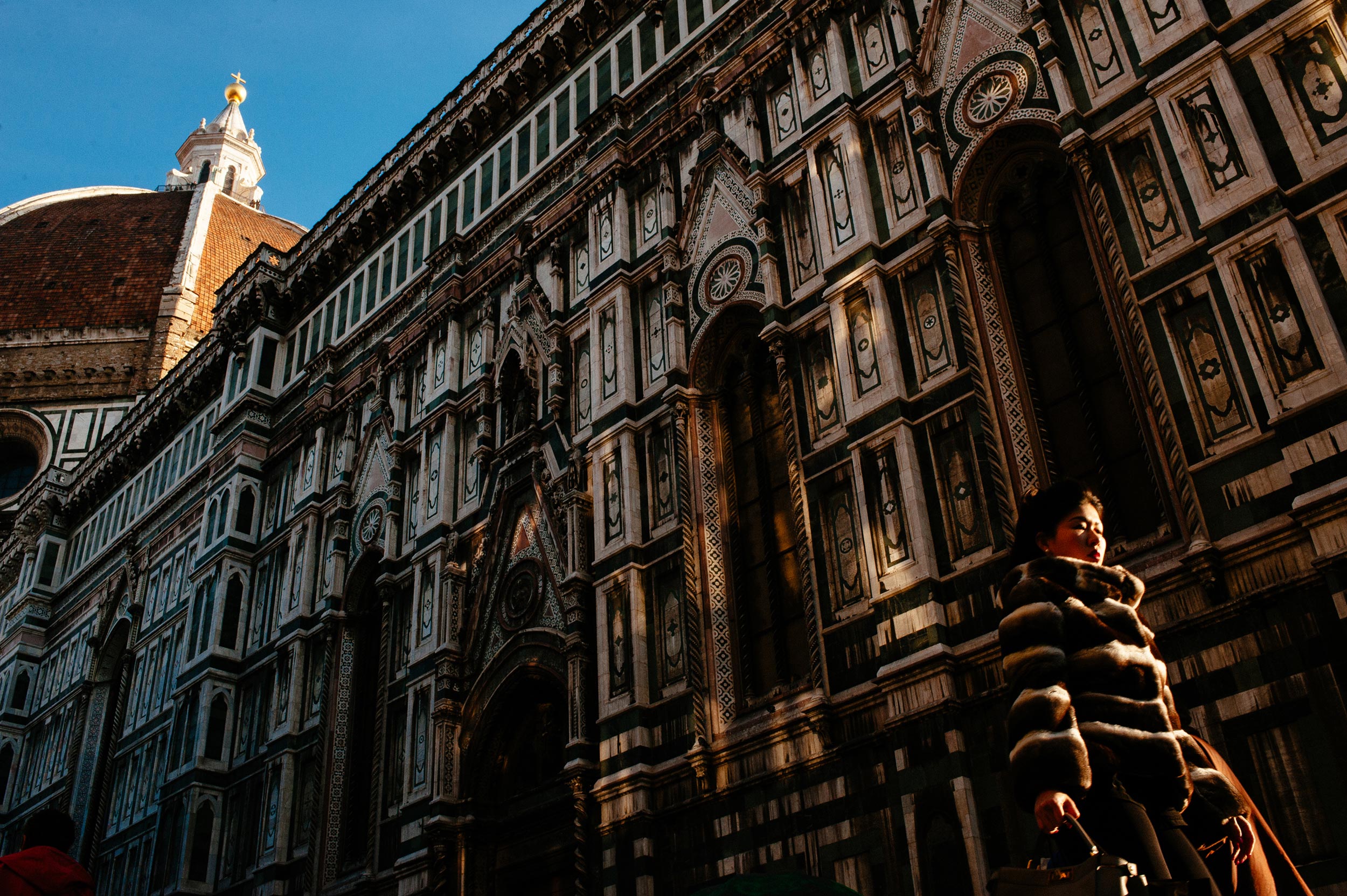 Florence Italy - Woman walking in fur coat, same pattern as church