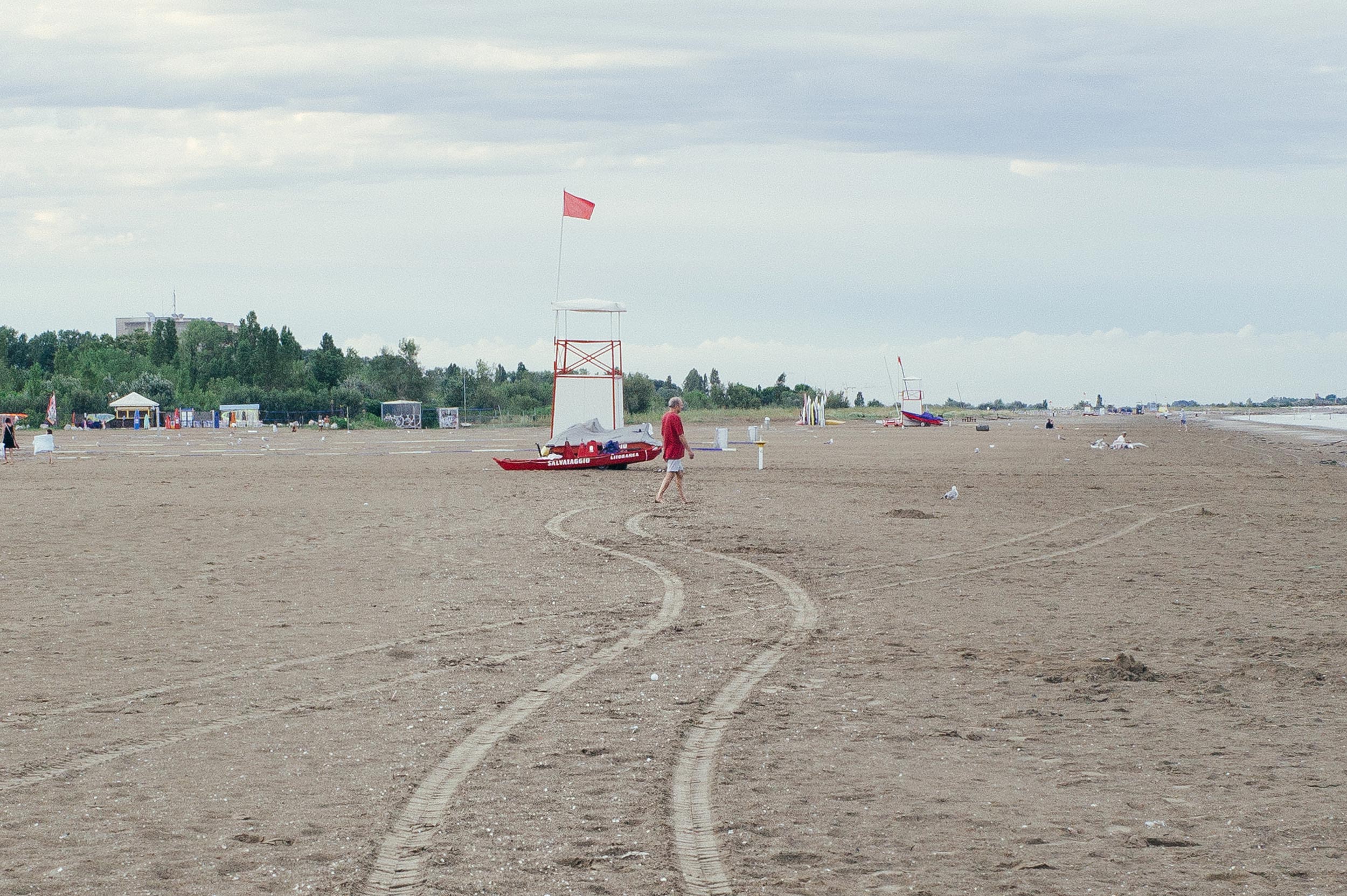 Venice 2016 - Man walking on the beach, legs following trails