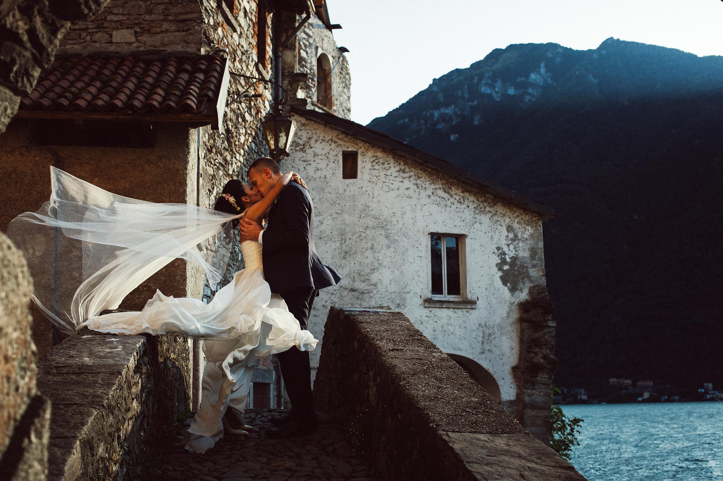 beautiful kiss in lake como windy sunset on a bridge